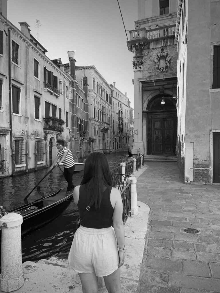 Foto van Shukrije Suhodolli bij de gondels op het water in Venetië.